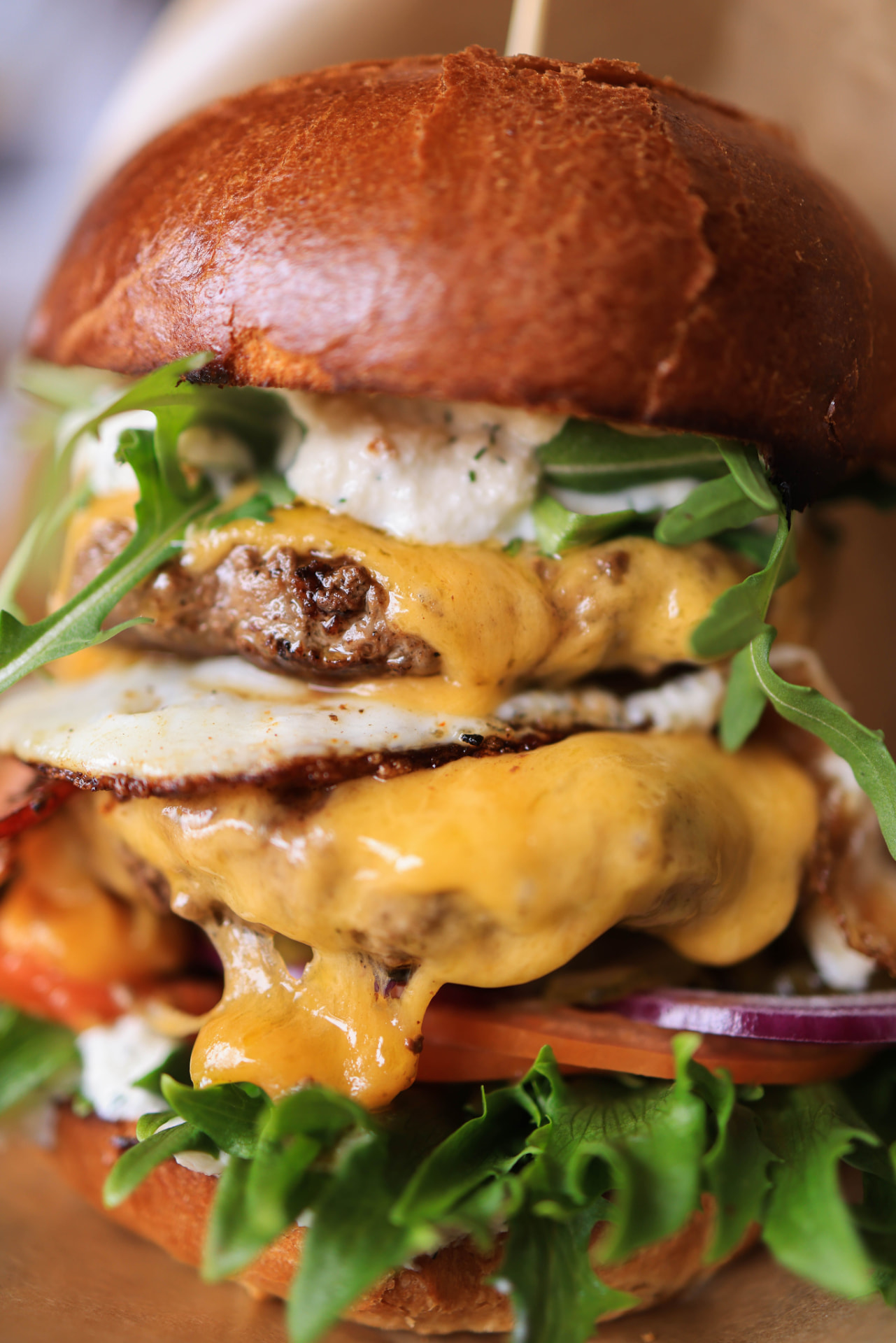 Cheeseburger with fried egg, melted cheddar, and arugula